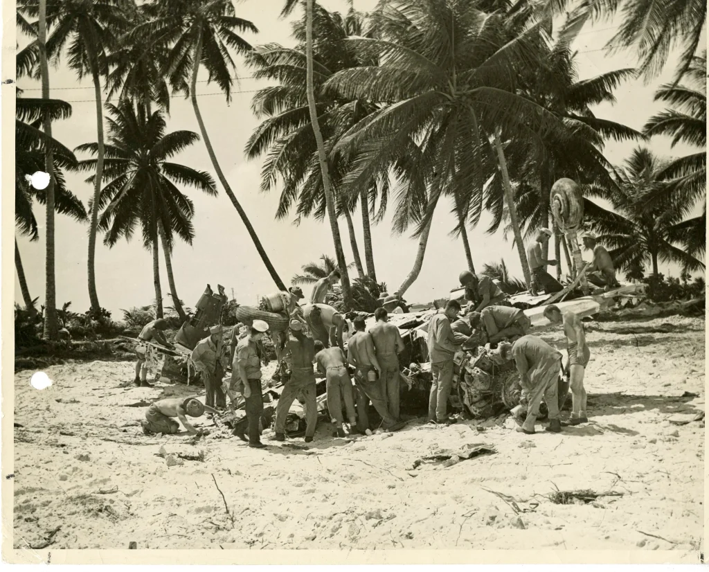 Seabees swarming wreckage of a Japanese dive bomber, Gilbert Islands.